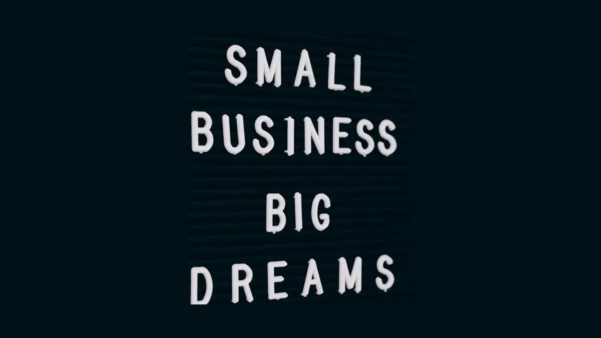 Tablica z białymi literami układającymi napis Small Business Big Dreams
