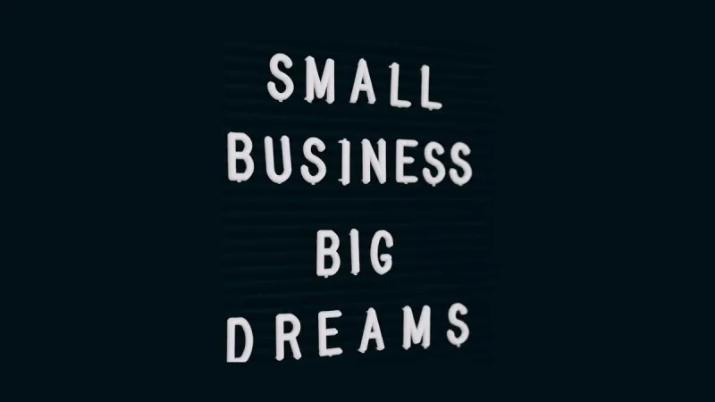 Tablica z białymi literami układającymi napis Small Business Big Dreams